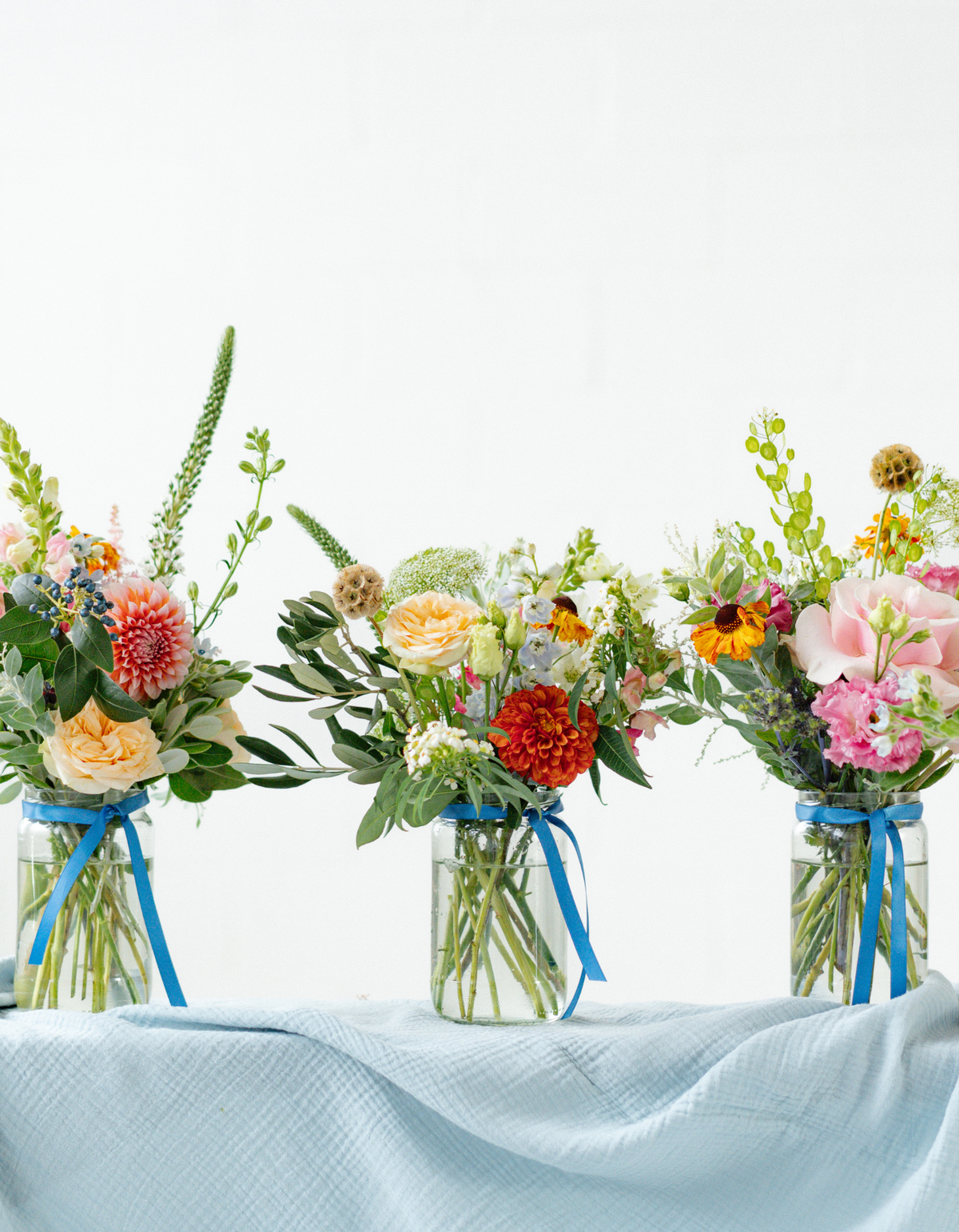 Three colourful Memento event flower arrangements