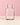 Alea clear glass vase with rounded shoulders and a narrow neck, on a neutral surface against a soft pink background